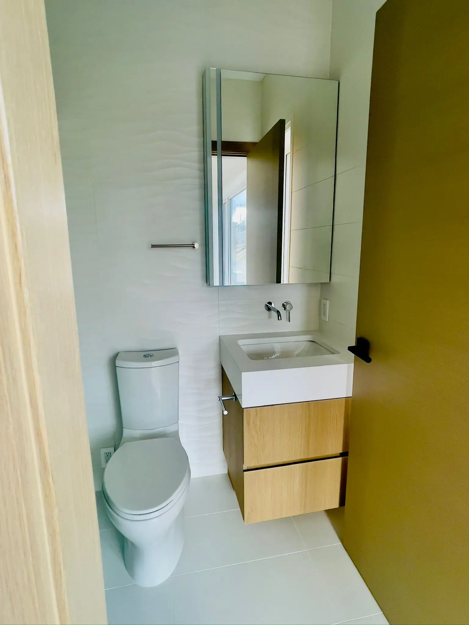 A cloakroom finished with a wall-hung vanity and a close-coupled toilet.