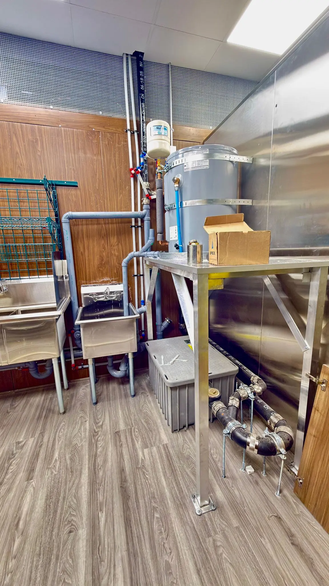 Kitchen sinks and a water heater piped in during a restaurant fit-out.