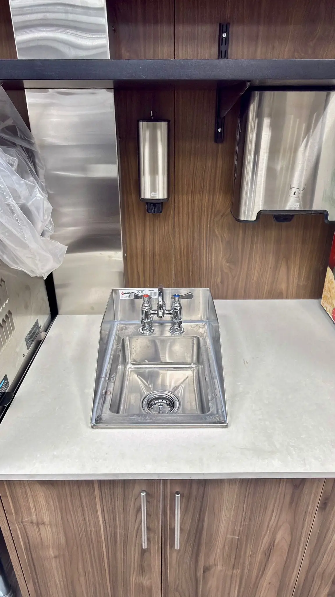 A two-compartment drop-in sink plumbed into a service counter.
