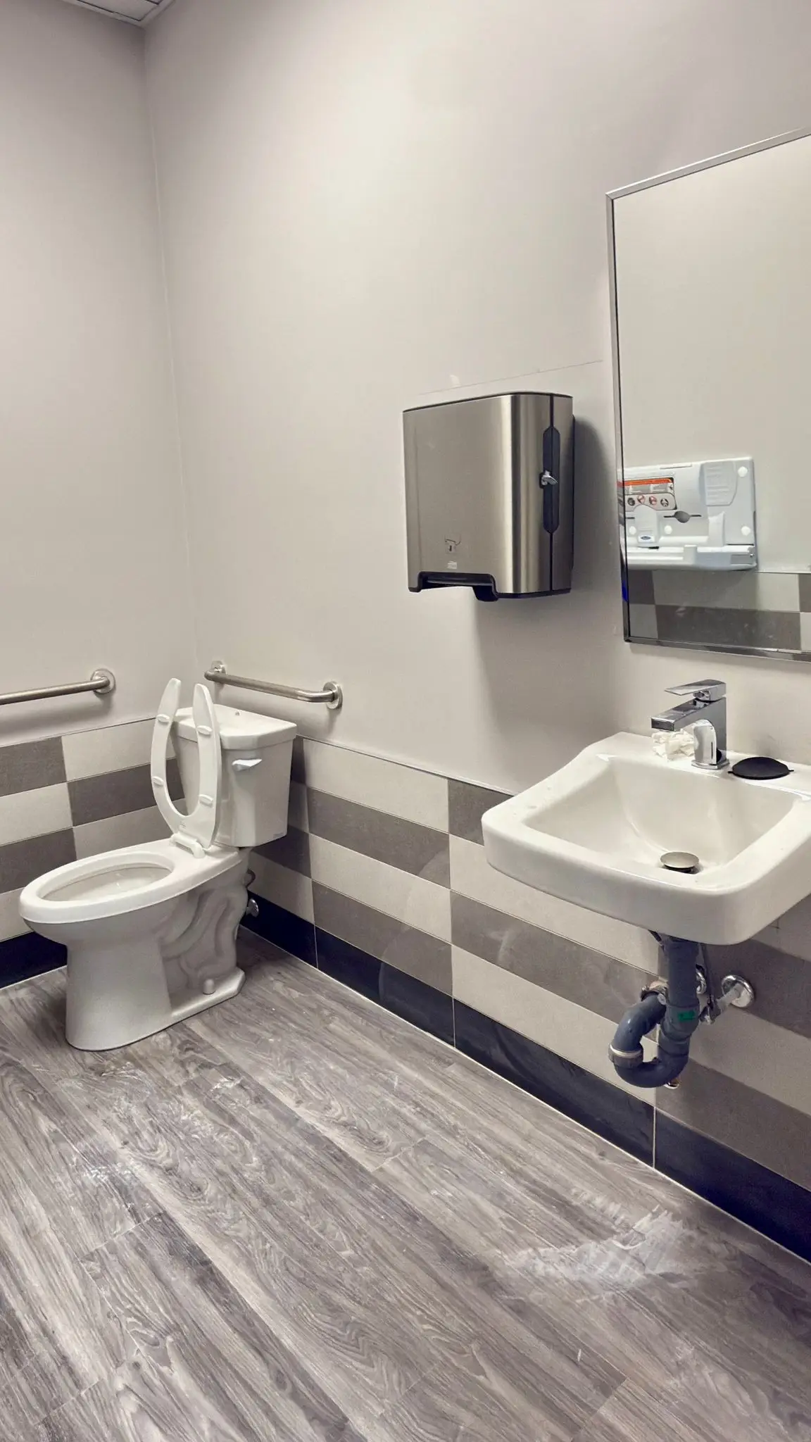A finished commercial washroom with an accessible toilet and basin.