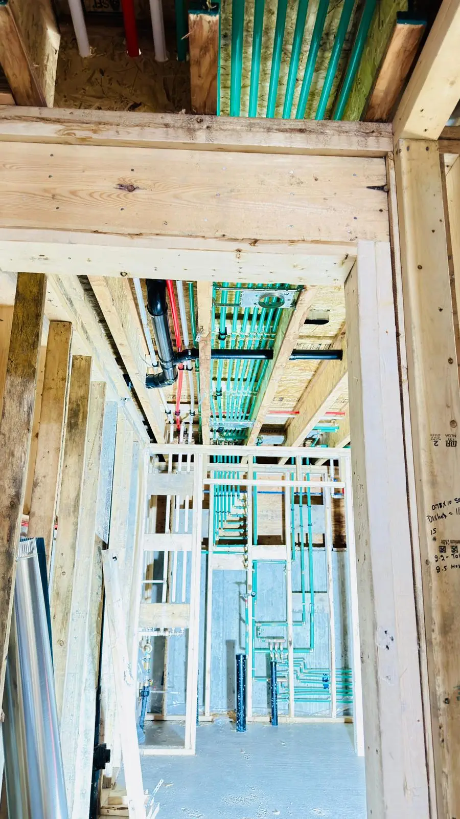 Radiant heating tubing carried across the joists above a doorway.