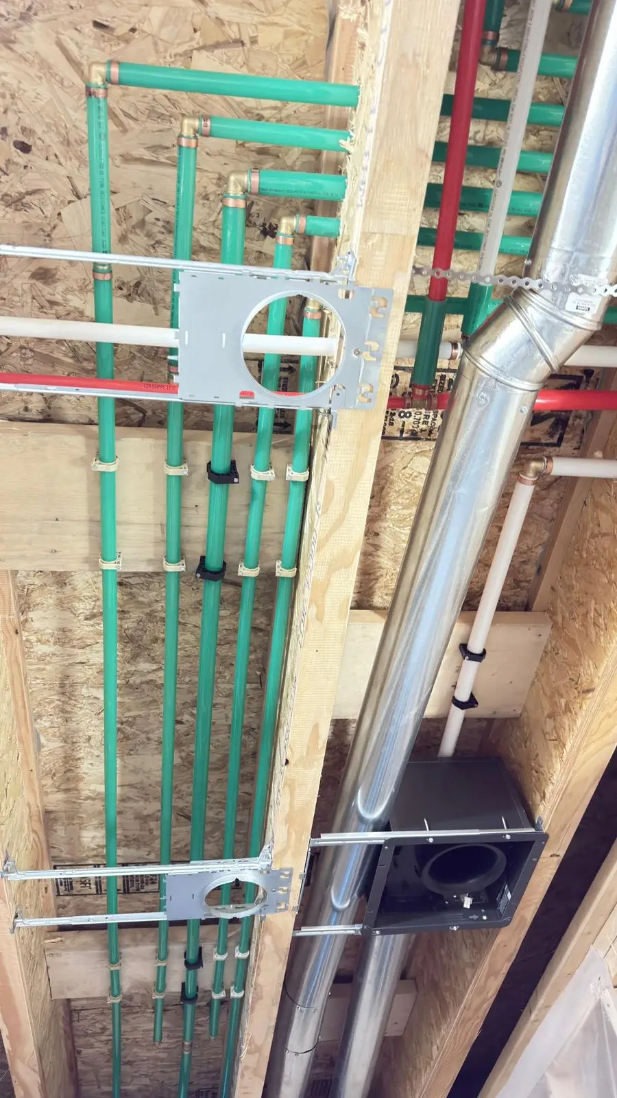 Radiant tubing run overhead alongside the domestic supply and the ductwork.