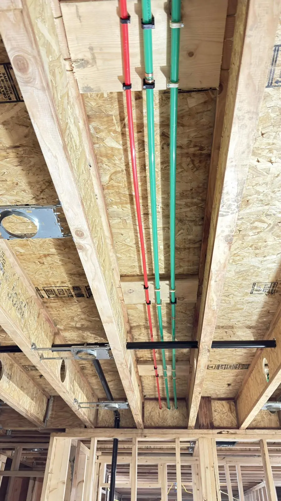 Radiant heating and domestic supply lines sharing the same joist bays.