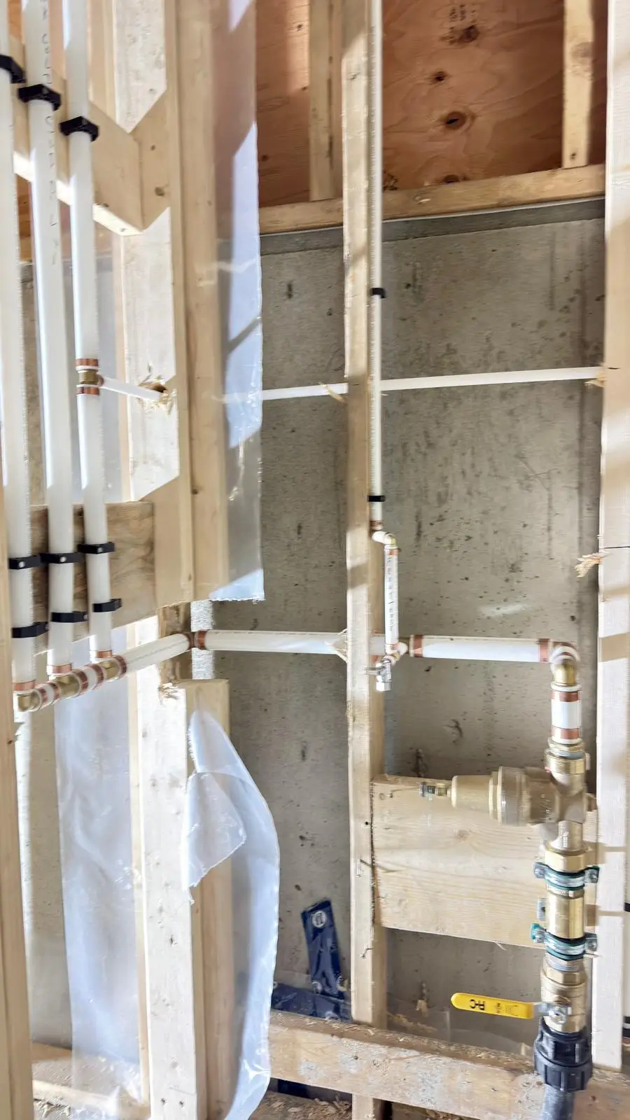 Heating pipework made up against a poured concrete wall.