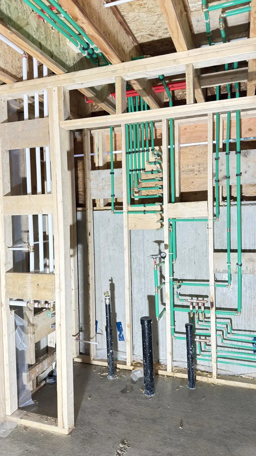 A radiant heating manifold roughed into a framed mechanical space.