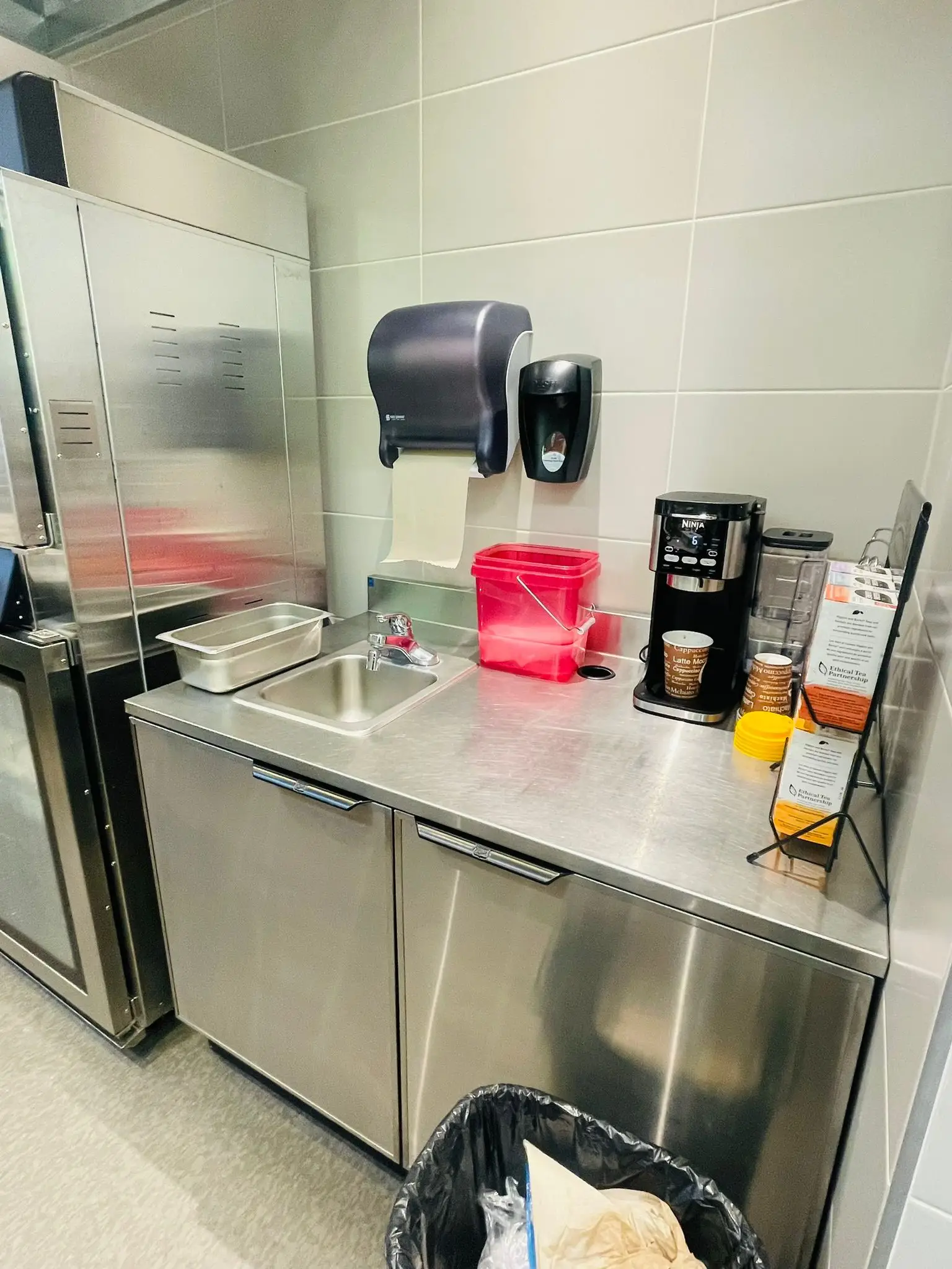 A stainless prep counter and sink installed in a restaurant back of house.