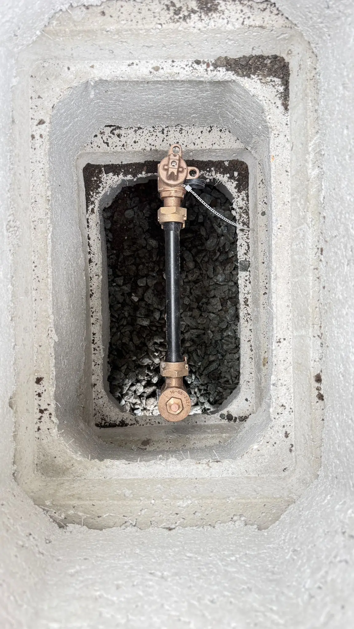 A water service valve set in its concrete meter box.