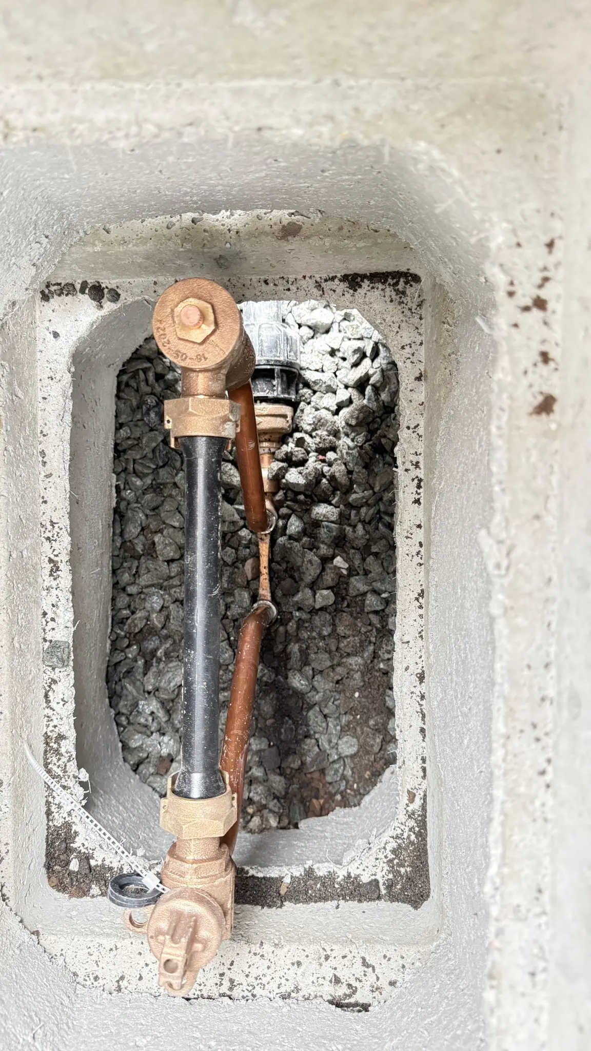 A new water meter and copper service connection set in its box.
