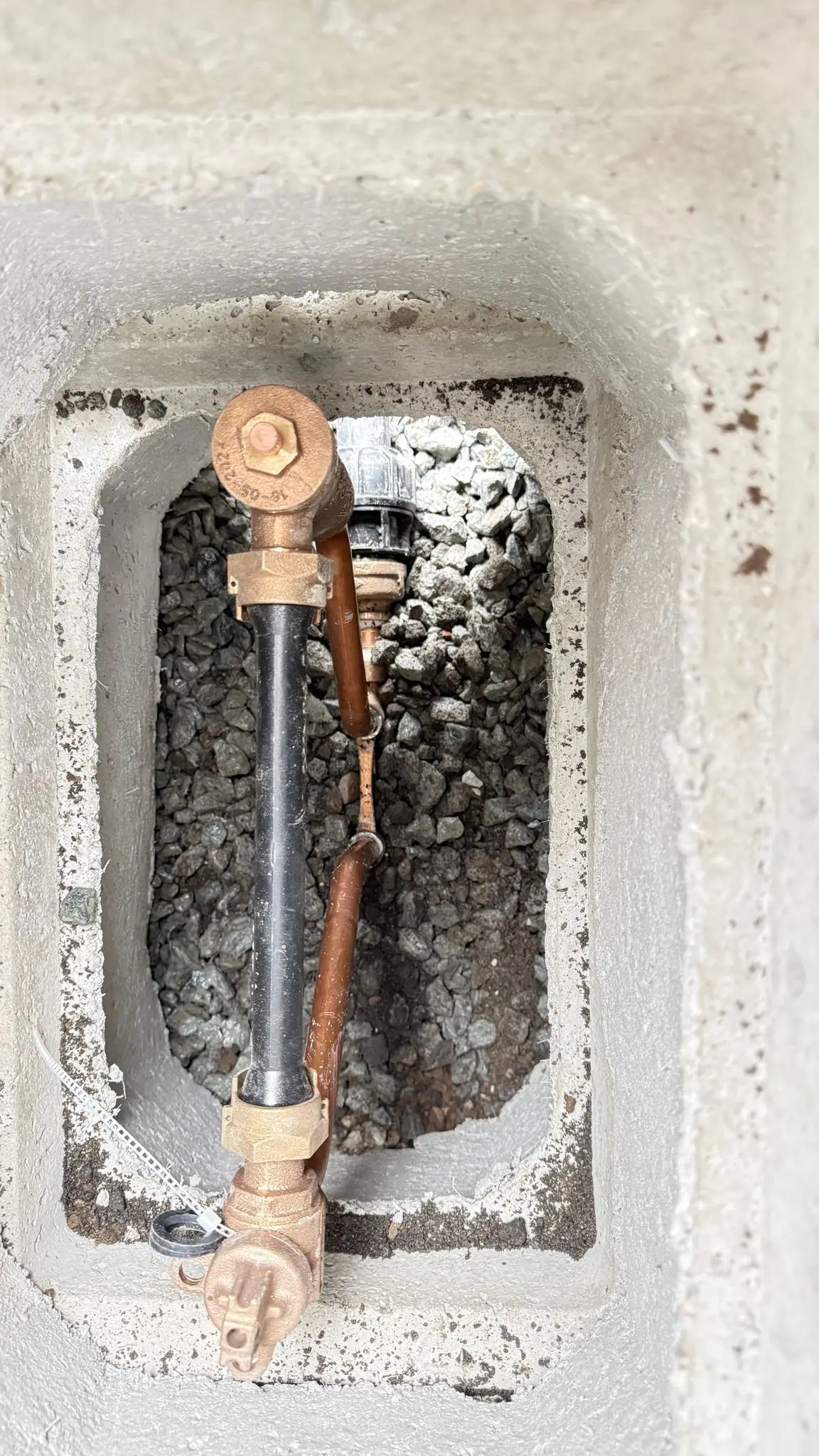 A new water meter and copper service connection set in its box.