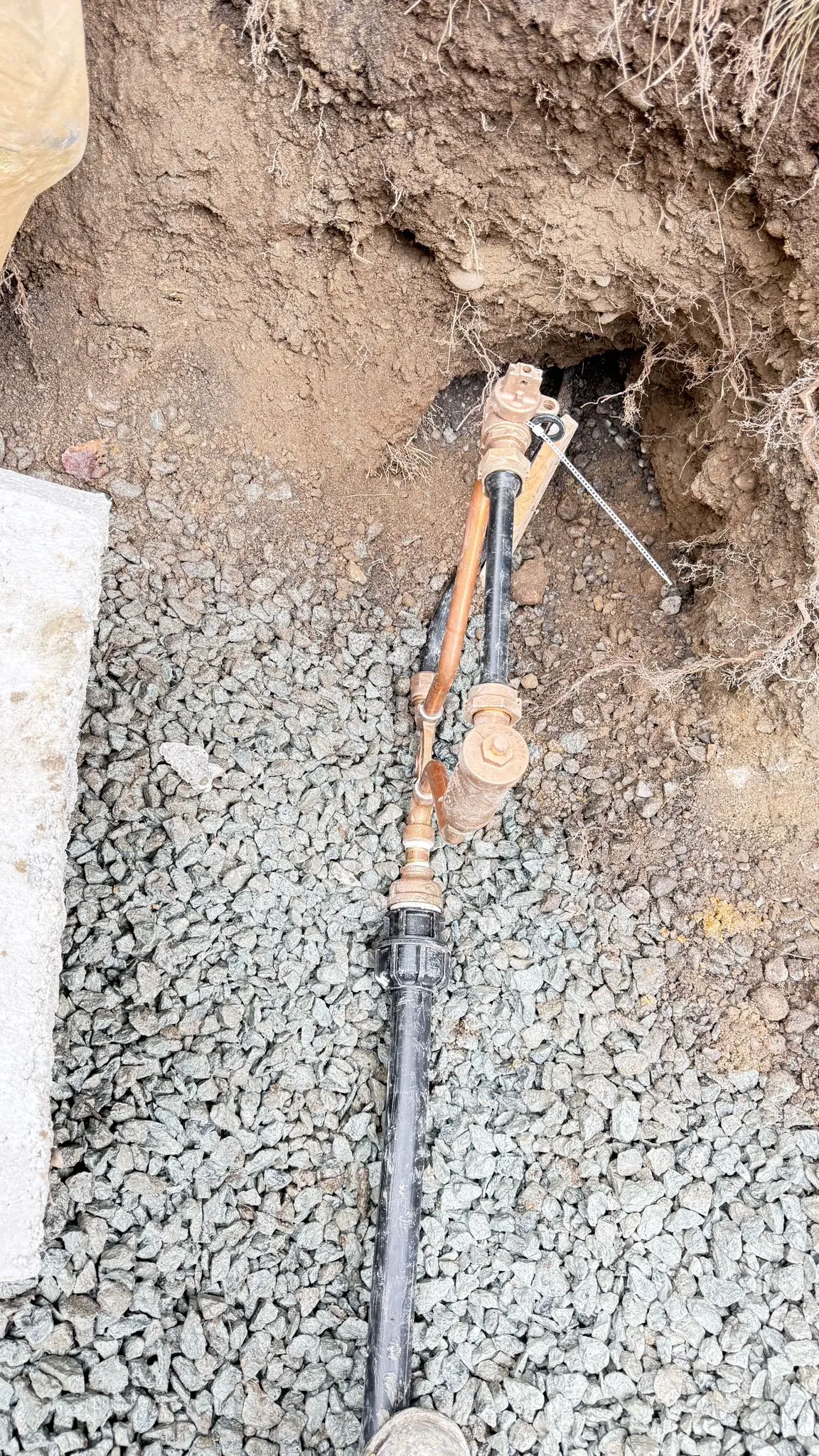 A water service valve fitted in the open trench before backfill.